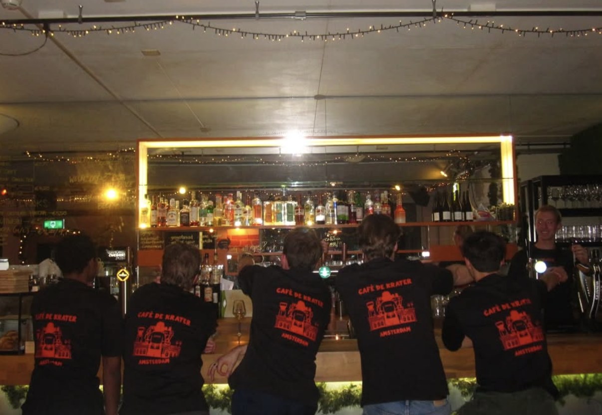 The team in Café De Krater shirts at the bar